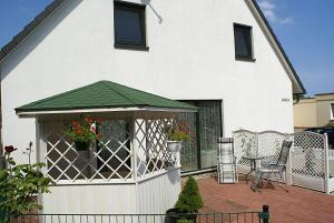 une maison blanche avec un kiosque sur une terrasse dans l'établissement Ferienwohnung Am Schlosspark, à Putbus