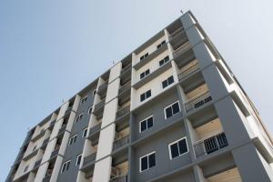 een appartementencomplex met balkons tegen een blauwe lucht bij Lampang Residence in Lampang