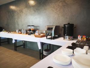 a kitchen with white tables with food on them at Lampang Residence in Lampang