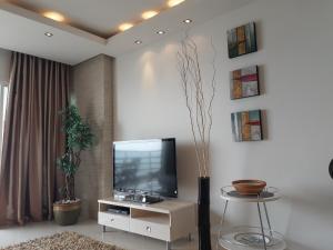 ein Wohnzimmer mit einem Flachbild-TV und einem Tisch in der Unterkunft Studio Veiwtalay 7 in Pattaya South