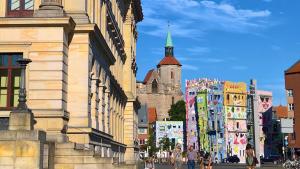 a group of people walking down a city street with buildings at Hotel am Park in Braunschweig