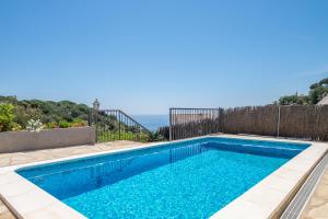 a swimming pool with the ocean in the background at Villa Bouganvilla in Tossa de Mar