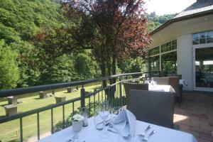 a table on a balcony with a view at Cocoon Hotel Belair in Bourscheid