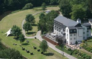 an aerial view of a large white building on a hill at Cocoon Hotel Belair in Bourscheid