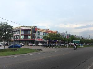a person riding a bike down a street with a building at BENUTHOMESTAY in Johor Bahru