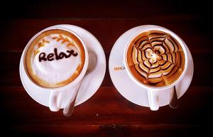 two cups of coffee on plates on a table at Phi Phi Relax Beach Resort in Phi Phi Islands