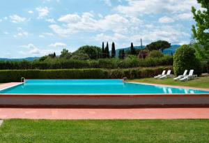 a swimming pool in a yard with two lounge chairs at Hotel Villa Cappugi in Pistoia