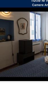 - une chambre avec un lit et une télévision dans l'établissement Camere Anna, à Vernazza
