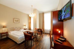 1 dormitorio con cama, mesa y TV en Self Check-in Time Out City Hotel Vienna, en Viena