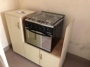 a stove sitting on top of a cabinet in a kitchen at Résidence Comara in Marcory
