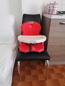 una silla roja sentada junto a una cama en Casa Vacanze "Il Carruggio", en Caltagirone