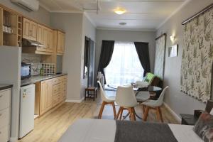 a kitchen with a table and chairs and a dining room at Caesar's Self-catering Open Plan Suite in Somerset West