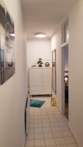 een keuken met witte kasten en een tegelvloer bij Ferienwohnung Univers 2 in Bad Harzburg +18 foto's