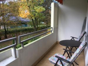 einen Balkon mit 2 Stühlen, einem Tisch und einem Fenster in der Unterkunft Brilliant Home Messe in Nürnberg