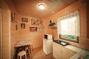 a small kitchen with a small table and a window at Komandorówka in Szczawne