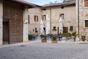 un edificio con sombrillas, mesas y sillas en Agriturismo Ca' Verde, en SantʼAmbrogio di Valpolicella