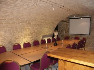 a conference room with tables and chairs and a screen at Hôtel Wilson - Teritoria in Dijon