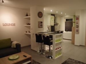 a living room with a kitchen with a counter and chairs at Ferienlounge in Salzhemmendorf