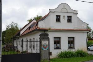ein weißes Haus mit einem Zaun davor in der Unterkunft Ubytování Hrusice in Hrusice