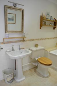 a bathroom with a sink and a toilet and a mirror at Stroud House in Freshwater