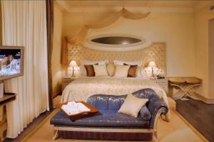 a bedroom with a bed with a couch in it at Excelsior Hotel & Spa Baku in Baku