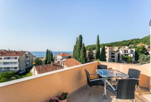 balcón con mesa, sillas y vistas al océano en Apartments Aleksandar, en Petrovac na Moru