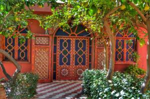 Riad les jardins Mabrouk في تارودانت: مدخل إلى منزل مع باب خشبي مزخرف