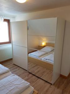 ein Schlafzimmer mit zwei Betten und einem großen Spiegel in der Unterkunft Wohnung Burgstaaken in Fehmarn