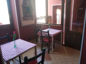 two tables and chairs in a room with windows at i milord in Castel San Giorgio