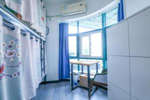 重庆弱水咖啡国际青旅 Only Cafe and Backpacker的一间医院房间,配有桌子和窗户 更多46张照片
