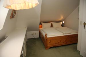 a small bedroom with a bed in a attic at Haus am Watt in Munkmarsch