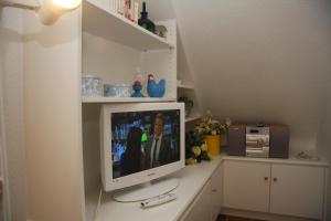 a computer monitor sitting on a counter in a room at Haus am Watt in Munkmarsch