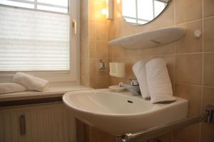 a bathroom with a white sink and a mirror at Haus am Watt in Munkmarsch +22 photos