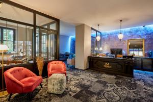 a living room with a desk and two chairs at Hôtel-SPA Le Moulin De La Wantzenau - Strasbourg Nord in La Wantzenau