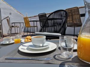 a table with a plate of food and a glass of orange juice at Hotel Boutique Caireles in Córdoba