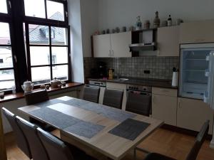 a kitchen with a table with chairs and a kitchen withlishes at St Maximin City Ferienwohnungen in Trier