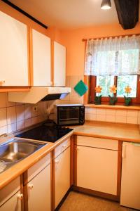 una cocina con fregadero y microondas en Ferienhaus Rodewald, en Bomlitz