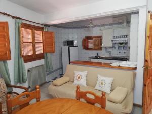 a living room with a couch and a kitchen at Apartamentos Cerro Negro - Los Magalites in Capileira