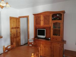 a living room with a tv on a wooden cabinet at Apartamentos Cerro Negro - Los Magalites in Capileira