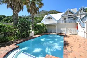 a house with a swimming pool in front of a house at 6 Jamaica Beach in Hout Bay