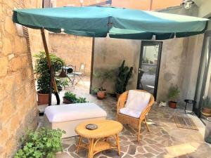 a patio with a blue umbrella and chairs and a table at INDUSTRIAL CHIC HOUSE - Private parking in Orvieto