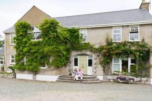 2 personnes assises sur les marches d'une maison dans l'établissement Buvinda, à Drogheda