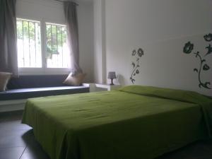 ロザスにあるApartaments La Rieraのベッドルーム(緑のベッド1台、窓付)