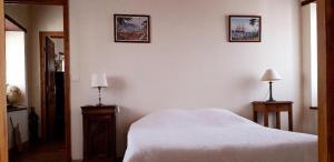1 dormitorio con 1 cama blanca y 2 cuadros en la pared en Maison Bidegain Berria, en Ispoure