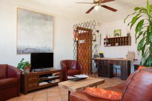 a living room with a couch and a television at Hostal La Palmera in Torremolinos