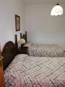 a bedroom with two twin beds and a lamp at Apartamentos Cerro Negro - Los Magalites in Capileira