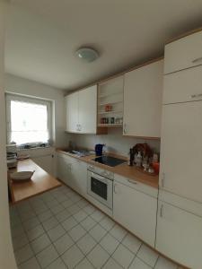a kitchen with white cabinets and a sink and a window at Wohnung im Herzen von Ettlingen in Ettlingen