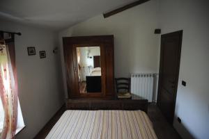a bedroom with a mirror and a bed in it at La Miniera in Montefollonico