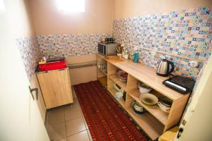 a small kitchen with wooden shelves and a microwave at Lizak in Berehove