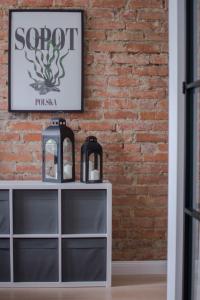 a brick wall with a sign on top of a shelf at Apartament Andersa in Sopot